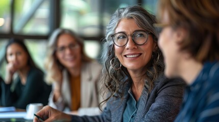 Fototapeta premium Happy middle aged businesswoman working with diverse colleagues at office