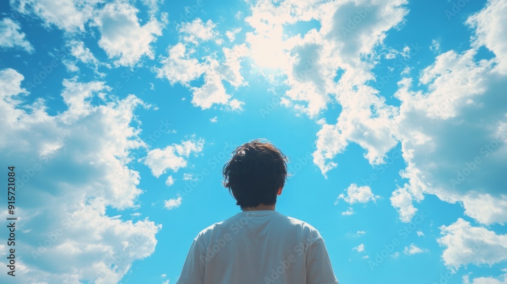 Poster a man is standing in the sky looking up at the clouds