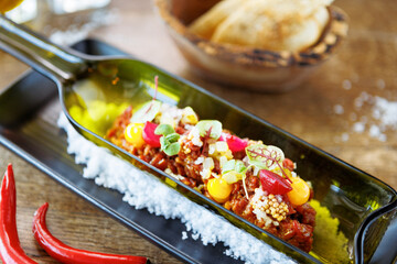 Beef tartare from Black Angus. Egg yolk, pickled cucumber, shallot, pearl onion, coriander and mustard seeds. Delicious healthy Italian food served for lunch in modern gourmet cuisine restaurant