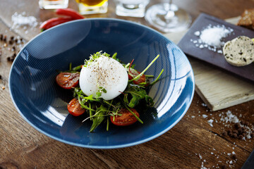 Burrata with paprika-truffle jam and cherry-cluster tomato salad. Delicious healthy Italian traditional food closeup served for lunch in modern gourmet cuisine restaurant