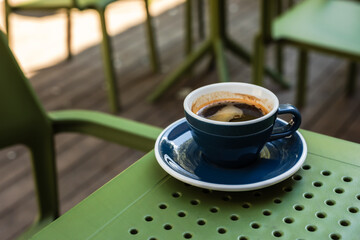 A cup of black coffee on a cafe terrace