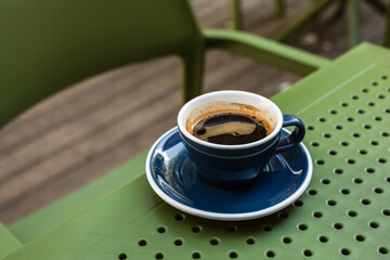 A cup of black coffee on a cafe terrace