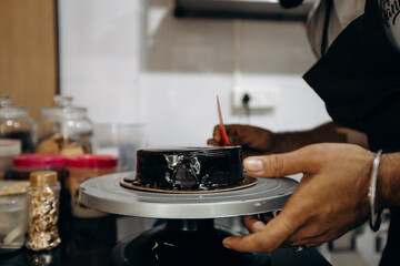 A Baker meticulously puts final touches on a cake in a professional kitchen setting