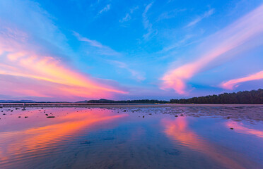 amazing colorful cloud in sunset above Pling island at Naiyang beach Phuket. A peaceful twilight scene featuring a stunning gradient sky transitioning from deep purple to warm orange as night falls.