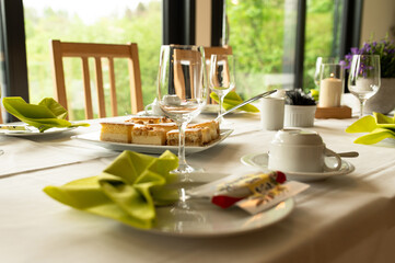 a table set with cups, glasses and dessert plates