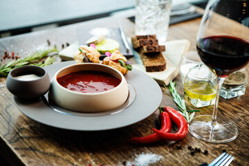 Beetroot soup Borscht with meat and sourcream in a bowl. Delicious healthy Ukrainian traditional food closeup served for lunch on a table in modern gourmet cuisine restaurant