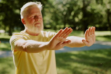 Obraz premium Medium close up of senior man hands in karate position, they illuminated with sun rays