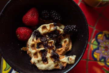 half eaten gluten free waffle with strawberries and blackberries