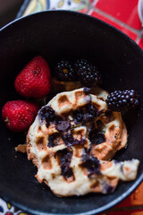 half eaten waffle with a side of fruit