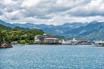 Dramatic mountains covered with lush greenery on the coast of Pacific Ocean in Nachikatsuura, Wakayama, Japan, part of the Yoshino-Kumano National Park.