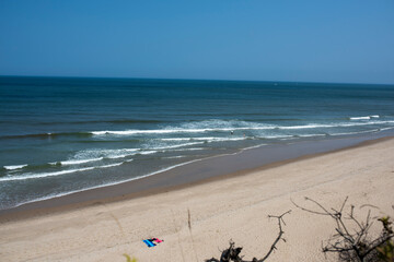 colorful blankets lie on a cape cod ocean beach during the height of summer