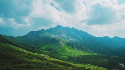Fototapeta premium Green Mountain Range Under a Cloudy Sky