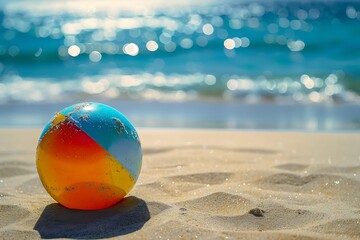 Obraz premium A vibrant beach ball rolling on the sand, clear blue ocean backdrop, sunny day, shadows cast by the ball, bright and colorful scene, high clarity, dynamic composition