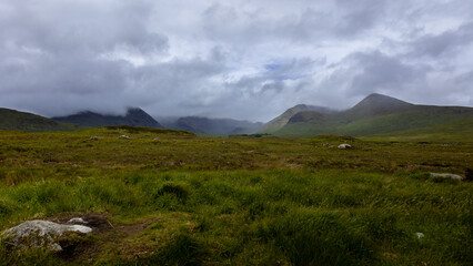 Obraz premium The beautiful Scottish landscape with hills, mountains, water, lakes, cloudy skies and misty views