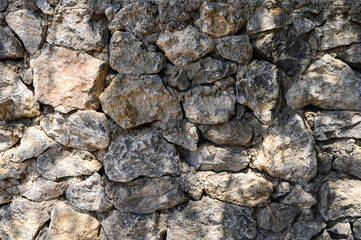 light and shadow on a wall made of real stone close-up texture