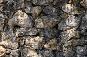 wall made of real stone close-up sun rays