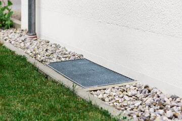 Drain Stones Pebbles Floor with Downspout and Grate of Drainage System Outdoor. Foundation Drainage...