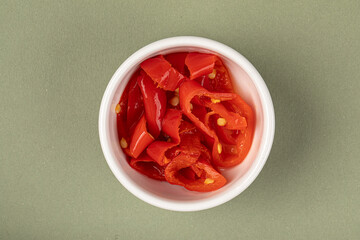 Portion of sliced red pepper in a small white bowl
