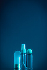 Means for face and body care. A complex of organic care products. Bottles for the transportation of cosmetics traveling by plane. Dark blue color scheme.