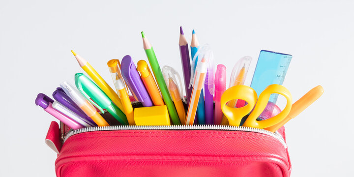 Back to school concept. Bright school pencil case with filling school stationery, pens, pencils, scissors, rule. School accessories on white background. Flat lay, top view, copy space