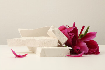 Stones platform podium, flower petal on beige background. Minimal empty display product presentation scene.