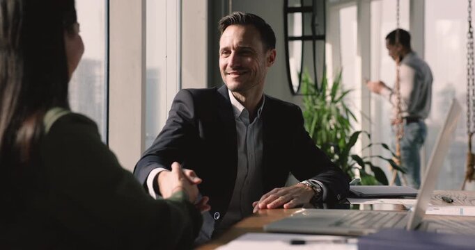 Business partners after discussion, shaking hands, reach joint goal express recognition for successful effective negotiations result. Closing profitable Commercial deal, sell and buy company services