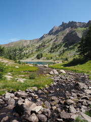 Alpine stream flowing through a green valley with rocky mountain peaks
