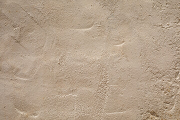 A close up of a textured pale beige wall