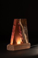 Night LED lamp made of wood and epoxy resin. Vintage lighting for a bedroom or hallway. Dark background for New Year or invitation cards. Christmas or Silvester day decoration layer. 