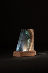 Night LED lamp made of wood and epoxy resin. Vintage lighting for a bedroom or hallway. Dark background for New Year or invitation cards. Christmas or Silvester day decoration layer. 