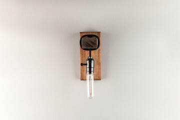 Vintage wall lamp to illuminate the terrace. Antique lamp with Edison bulb. The concept of saving energy or lack of ideas. Turned off lamp on a light background.