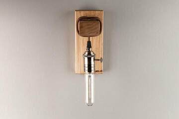 Vintage wall lamp to illuminate the terrace. Antique lamp with Edison bulb. The concept of saving energy or lack of ideas. Turned off lamp on a light background.