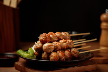 Meatballs on skewers placed on a ceramic plate