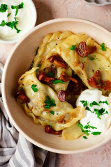 Polish dumplings with fried chanterelles and sour cream on a plate..style hugge.