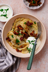Polish dumplings with fried chanterelles and sour cream on a plate..style hugge.