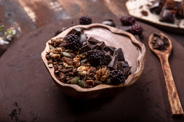 Healty breakfast.Healthy granola bowl with full of nuts and dark chocolate.Healthy lifestyle.Healthy fruits.Kitchen in background.