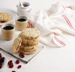 Cranberry shortbread cookies with two cups of coffee on the light table, morning breakfast, copy space