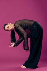 Fashion, asian woman in sheer top and black pants bending over on purple background with hands on...