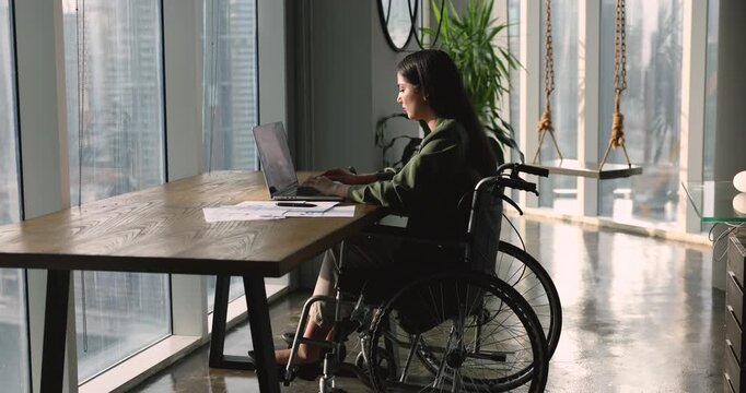 In modern home office Latina businesswoman, entrepreneur solve business remotely, doing on-line job, respond to company client by emailing, correspond to colleague seated in wheelchair. Workflow, tech