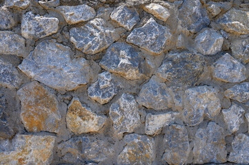 Grey stone wall with different sized stones, modern siding