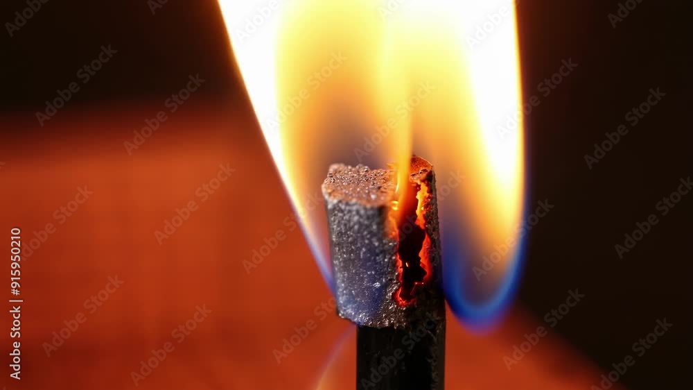 Poster Intense closeup of a match being struck against the rough surface of a matchbox igniting a bright flame that quickly dies down.