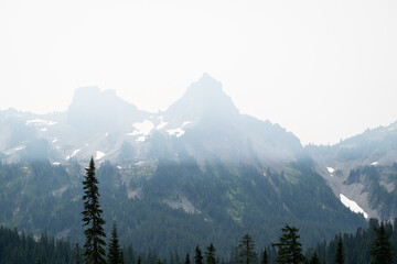 Obraz premium Smoke pollution over the Tatoosh Mountain Range from wildfires, viewed from paradise area of Mount Rainier National Park, poor summer air quality 