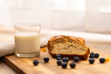 glass of milk and sweet homemade banana bread with crispy crust on a wooden board, dessert
