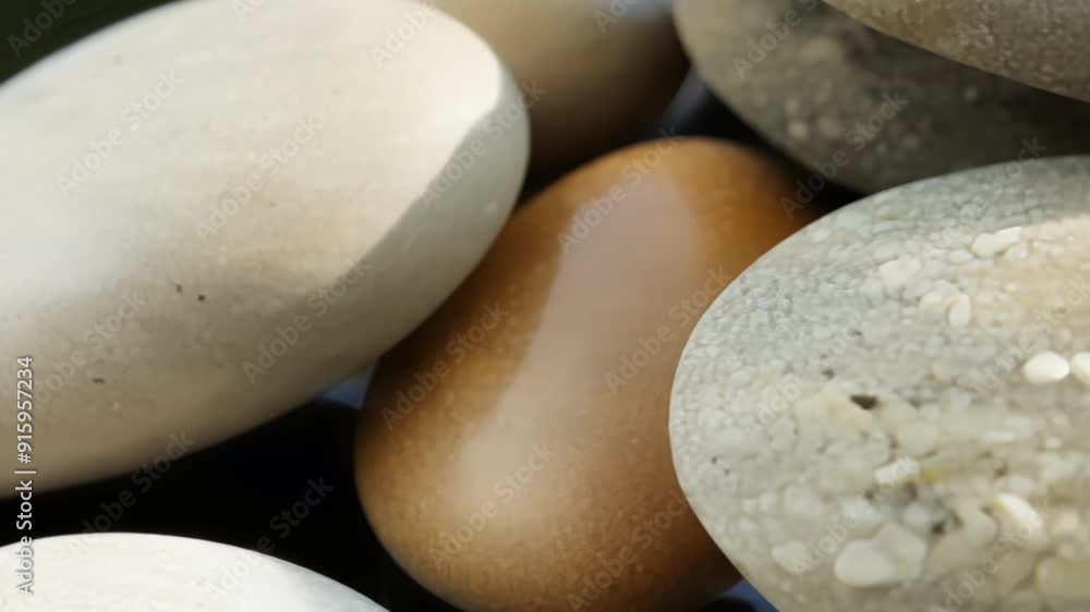 Poster Slow zoom in on a grouping of smooth pebbles showcasing the natural gradation of colors and sizes.