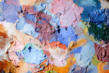 Colorful abstract texture. Smears of oil paint and a palette knife on an art palette. The concept of the modern school of art. Fragment of creative work. Colors of the year 2024