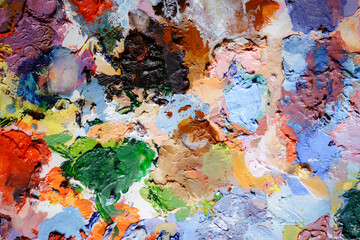 Colorful abstract texture. Smears of oil paint and a palette knife on an art palette. The concept of the modern school of art. Fragment of creative work. Colors of the year 2024