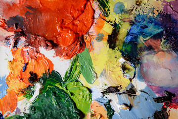 Colorful abstract texture. Smears of oil paint and a palette knife on an art palette. The concept of the modern school of art. Fragment of creative work. Colors of the year 2024