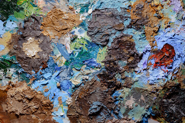 Colorful abstract texture. Smears of oil paint and a palette knife on an art palette. The concept of the modern school of art. Fragment of creative work. Colors of the year 2024