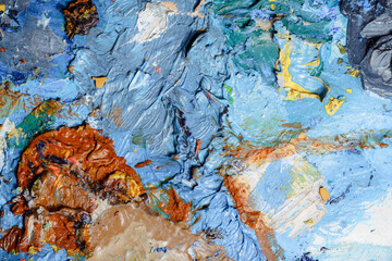 Colorful abstract texture. Smears of oil paint and a palette knife on an art palette. The concept of the modern school of art. Fragment of creative work. Colors of the year 2024