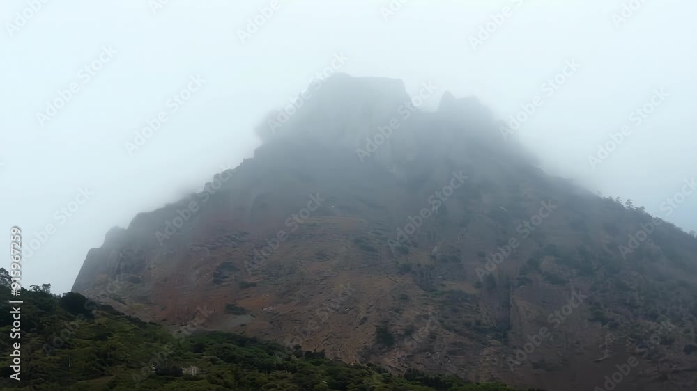 Poster The soft hazy outline of a distant mountain slowly becoming more defined as the fog begins to clear.